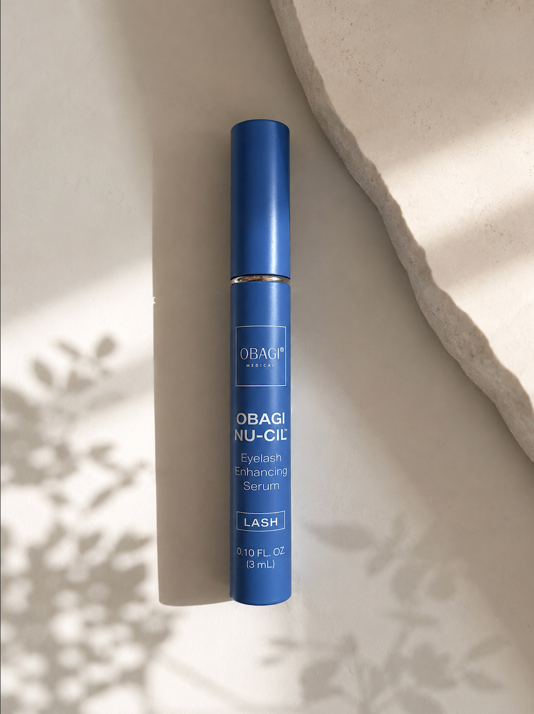 Obagi nu cil lash serum laying on white rock counter at L&P Skin Shop